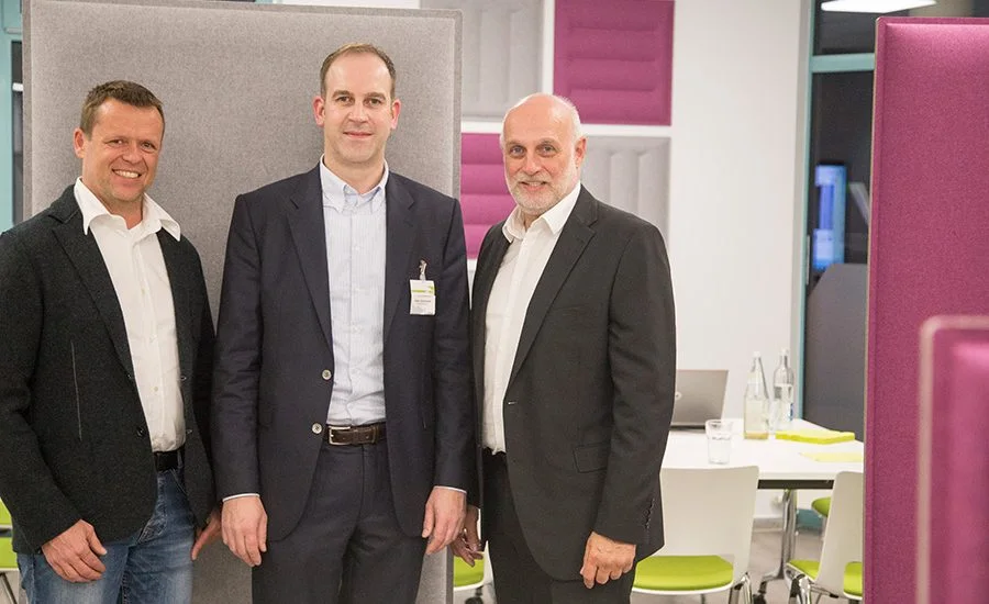 Drei Gäste vor Akustikelementen im Showroom